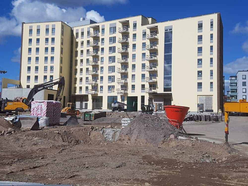 A group of 5 people standing and looking at a construction blueprint.